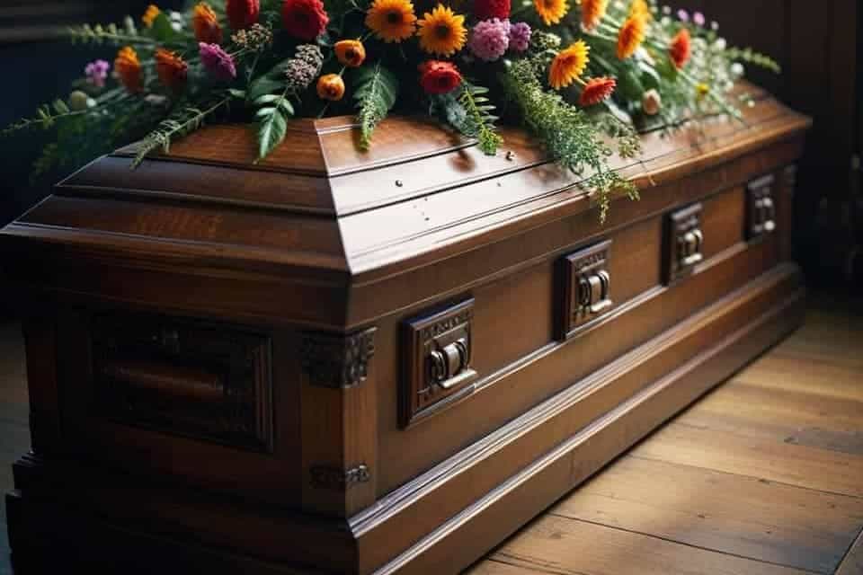 Ataúd de madera con flores coloridas encima