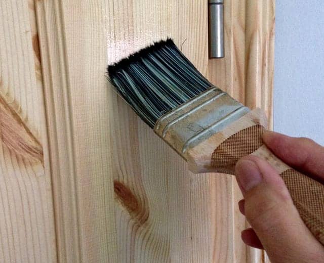 Pintando puerta de madera con brocha